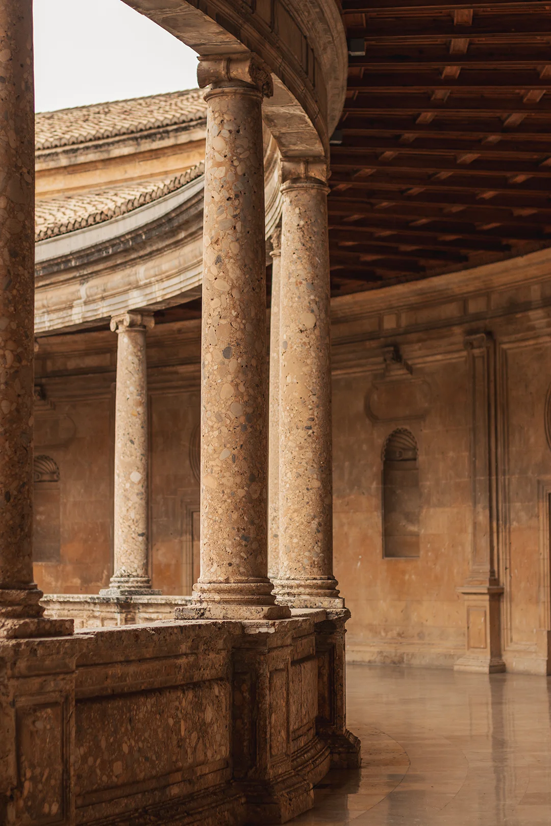 The magnificent Renaissance courtyard of the Palace of Charles V inside the Alhambra complex — its circular colonnade of marble columns is one of Granada's most stunning architectural settings. The magnificent Renaissance courtyard of the Palace of Charles V inside the Alhambra complex — its circular colonnade of marble columns is one of Granada's most stunning architectural settings.